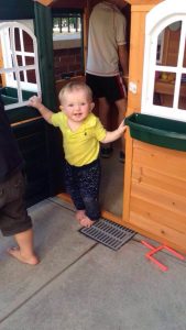 Toddler in door of playhouse smiling